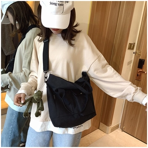 Black canvas tote bag for women featuring a detachable green frog plush pendant charm