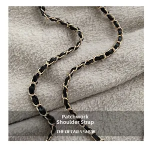Detail view of woven chain shoulder strap with gold metal and black leather texture