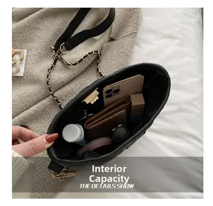Detail view of the large internal capacity of the black quilted crossbody bag