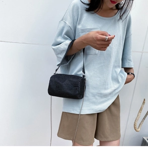 Détail d'un mini sac bandoulière noir avec strass et bandoulière en cuir avec chaîne
