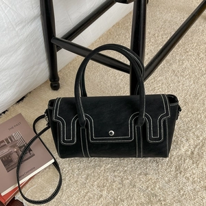 Sac à main rétro noir avec surpiqûres blanches contrastées et boucle argentée sur tapis doux
