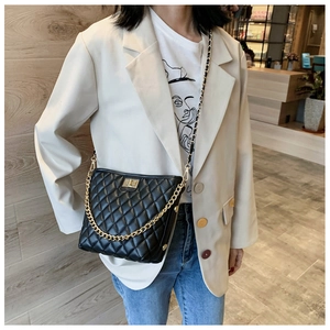 Detail of classic black quilted shoulder bag with gold twist lock and chain strap