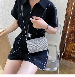 Détail d'un mini sac carré argenté orné de strass avec bandoulière en chaîne
