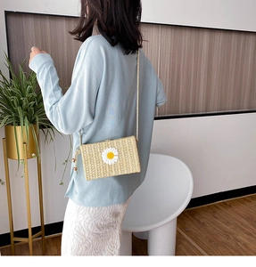 Détail du sac bandoulière en paille avec applique marguerite et bandoulière en corde