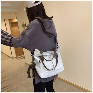 Canvas tote bag with SPORT label, olive green straps, and a plush frog pendant