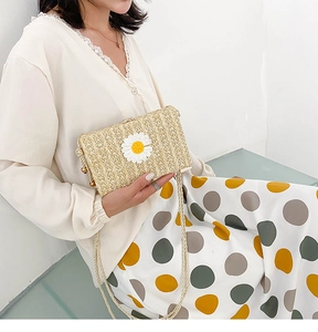 Détail du sac en paille tressée avec ornement marguerite blanche et bandoulière torsadée