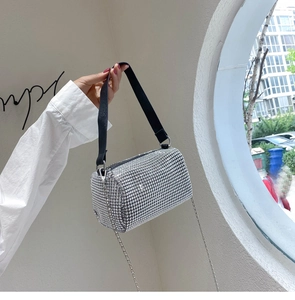 Détail du sac cylindre en strass argentés avec bandoulière noire et fine chaîne en argent