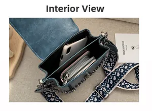 Innenansicht der blauen Lederhandtasche mit breitem Druckgurt und Metallkette