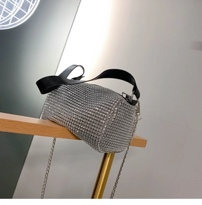 Détail du sac cylindrique en strass argentés avec poignée en cuir noir et bandoulière