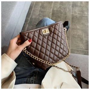 Detail of dark brown quilted crossbody bag with gold twist lock and chain strap