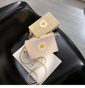 Détail de sacs bandoulière en paille tressée avec broderie marguerite et bandoulière corde