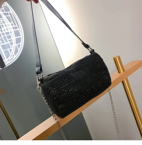 Détail du sac cylindre à strass noirs avec chaîne argentée et poignée en cuir