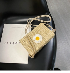 Détail du sac bandoulière en paille tressée avec marguerite brodée et sangle en corde