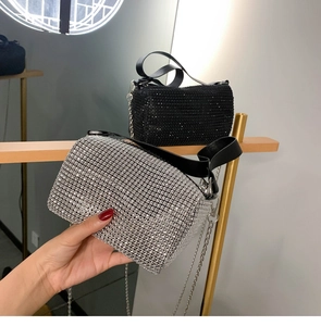 Détail d'un mini sac seau en strass avec surface en cristal et poignée en cuir