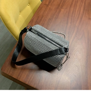 Vue de dessus d'un sac tonneau argenté en strass avec bandoulière cuir et chaîne