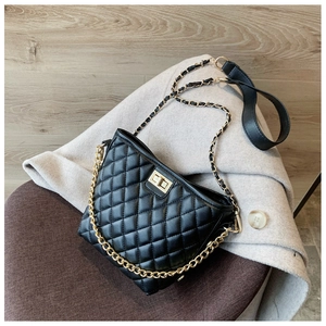 Detail of black quilted crossbody bag with golden square lock and dual shoulder straps