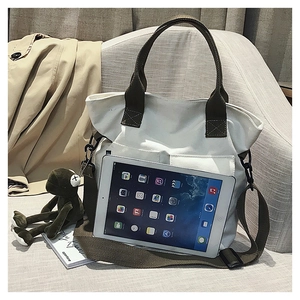 White canvas tote bag showing interior capacity with an iPad on a soft fabric sofa