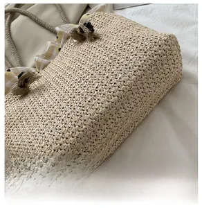 Close-up of wide base on straw tote bag with sunflower fabric and rope handles