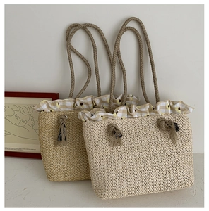 Detail of straw tote bags with floral ruffles and rope handles for beach vacation style