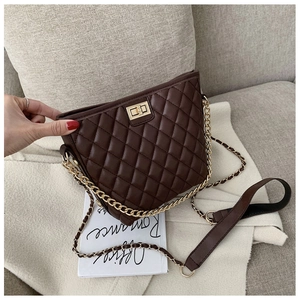 Detailed view of dark brown quilted crossbody bag with gold chain and metal twist lock