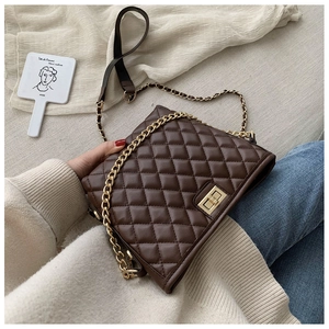 Detail of dark brown quilted crossbody bag with gold twist lock and chain strap