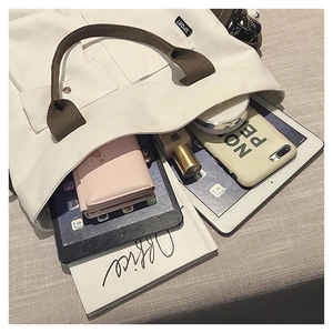 Interior view showing large capacity canvas tote bag with tablets and notebook