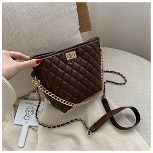 Detail of dark brown quilted shoulder bag with golden twist lock and chain strap