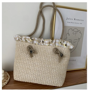 Close-up of woven straw tote bag featuring yellow plaid ruffles and sunflower prints