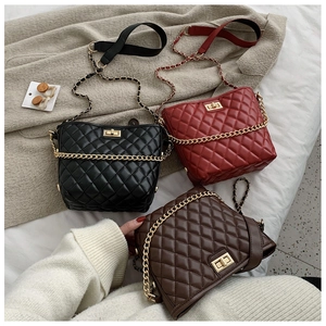 Detailed shot of quilted chain bags in black, burgundy and brown with gold twist locks