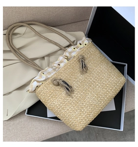 Detail of woven straw tote bag with floral gingham lining and braided handles for summer