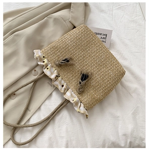 Close-up of straw tote bag with yellow gingham ruffles and sunflower prints detail