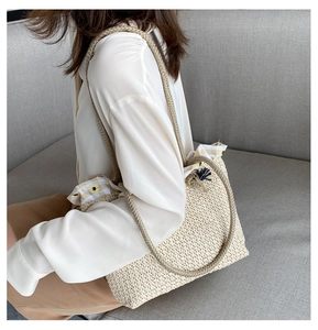 Close-up of woven straw tote bag with sunflower print lining and rope handle