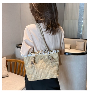Detail of straw tote bag featuring yellow plaid ruffles and woven rope shoulder straps