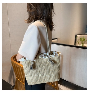 Detail of hand-woven straw tote bag with rope handle and sunflower print lining