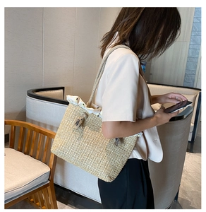 Detail of straw tote bag showing tight weave, floral drawstring lining and tassel charm