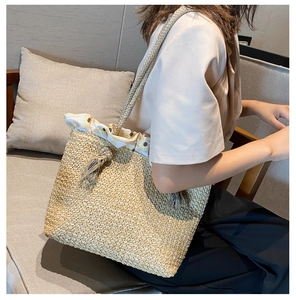 Detail of straw woven tote bag featuring sunflower print lining and decorative tassel