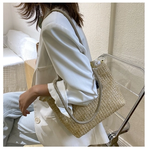Detail of straw woven tote bag featuring floral lining and slim shoulder straps