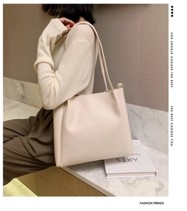 Detail of cream white tote bag with elegant pleat texture and thin shoulder straps