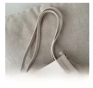 Close-up of the beige tote bag handles with elegant gold-tone hardware and neat stitching
