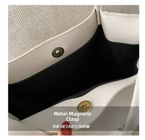 Detailed close-up of the vintage gold magnetic buckle on a cream leather tote bag