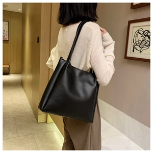 Minimalist black PU leather tote bag shown with slim straps and matte texture finish