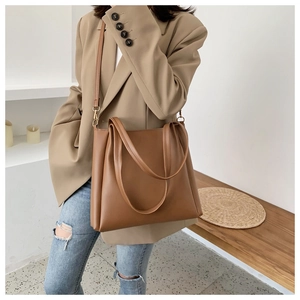 Brown leather tote bag featuring dual handles and adjustable shoulder strap for daily use