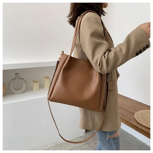 Close-up of caramel brown large tote bag with adjustable strap and gold hardware
