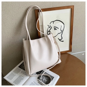 Close-up of beige PU leather tote bag with soft pleated details and gold-tone hardware