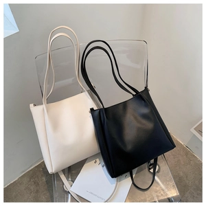 Minimalist PU leather tote bags in black and beige displayed on a modern chair