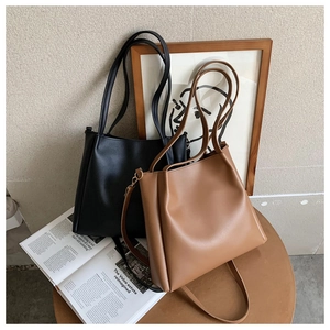 Classic black and brown leather tote bags on a table with an artistic lifestyle background