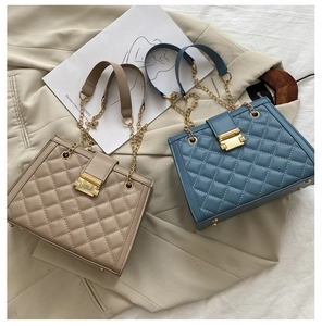 Dettaglio di borse a tracolla in pelle trapuntata beige e blu con fibbie dorate