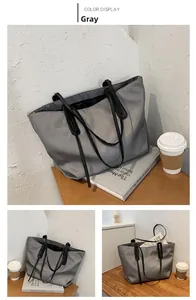 Detail view of a large grey nylon tote bag showing spacious interior and black shoulder straps