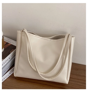 Close-up of beige faux leather tote bag with natural texture and slender straps