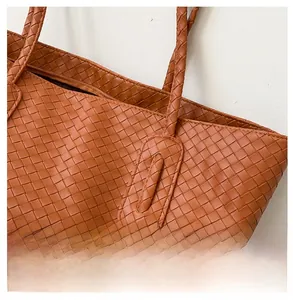 Close-up of the intricate brown woven texture and zipper closure of the tote bag